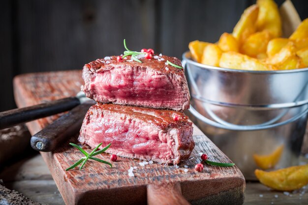 Primo piano di bistecca e patatine fatte in casa con sale e rosmarino