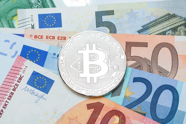 Primo piano di Bitcoin d'argento. Valuta euro di sfondo. Foto concettuale. Foto ad alta risoluzione.