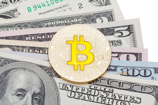 Primo piano di bitcoin giallo dorato su diverse banconote in dollari