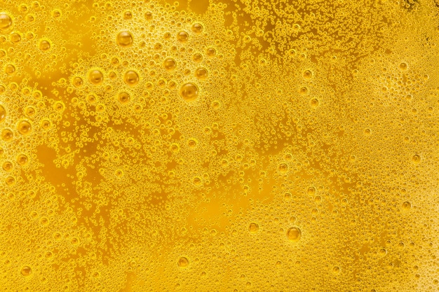 Primo piano di bolle di birra e schiuma come sfondo