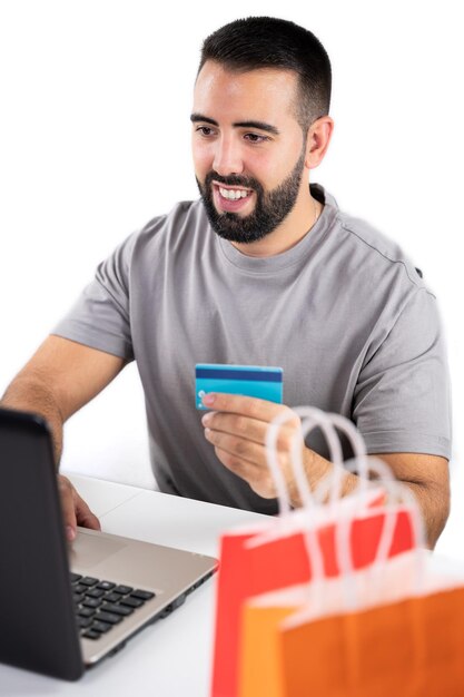 Primo piano di borse colorate e sfondo uomo irriconoscibile con computer e scheda di partecipazione per lo shopping online concetto shopping venerdì nero cyber lunedì vendite natale