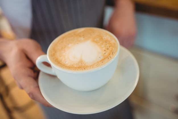 Primo piano di caffè servito da cameriera al bar