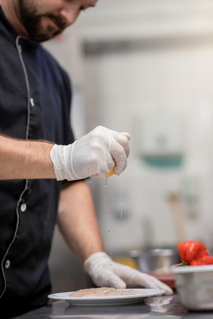 Primo piano di chef professionista che prepara carne di pollo sulla cucina del ristorante Concetto culinario