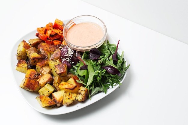 Primo piano di cibi cotti vegani fatti in casa su sfondo bianco Patate e carote