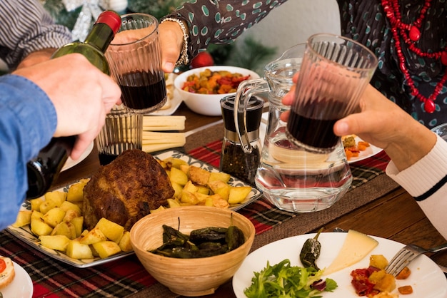 Primo piano di cibo e mani che prendono vino - cena familiare insieme o pranzo - festeggiare qualcosa