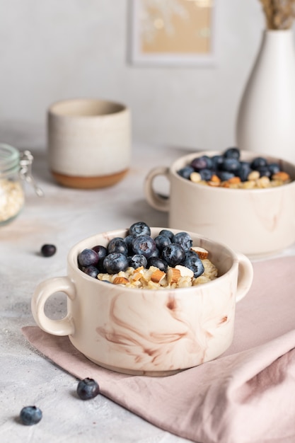 Primo piano di ciotole con porridge di farina d'avena con mirtilli per colazione