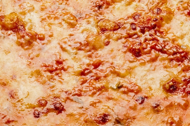 Primo piano di crosta di formaggio rosolato su pizza bolognese con carne tritata e salsa di pomodoro