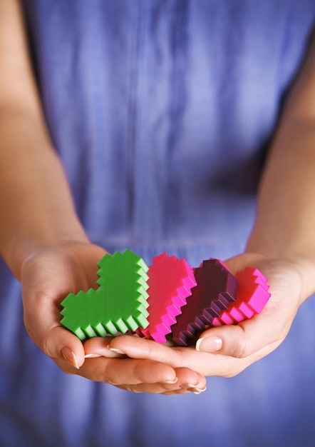 Primo piano di cuori di puzzle di plastica in mani femminili