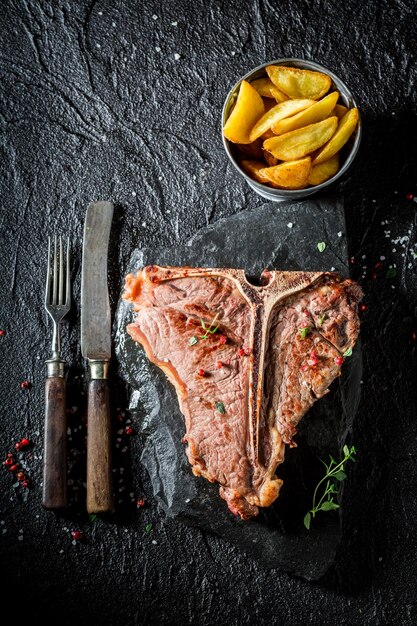 Primo piano di deliziose patatine e bistecca con l'osso