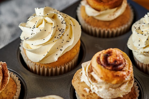 Primo piano di deliziosi cupcakes fatti in casa in una teglia condita con semi di vaniglia