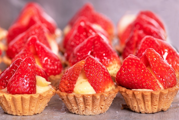 Primo piano di deliziosi tortini con fragole fresche e crema alla vaniglia.