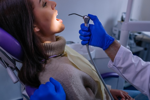 Primo piano di dentisti e paziente femminile con dentista a bocca aperta