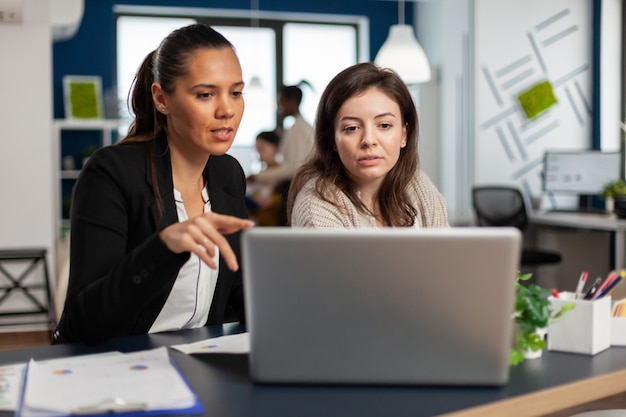 Primo piano di diverse donne d'affari che controllano i grafici dal laptop