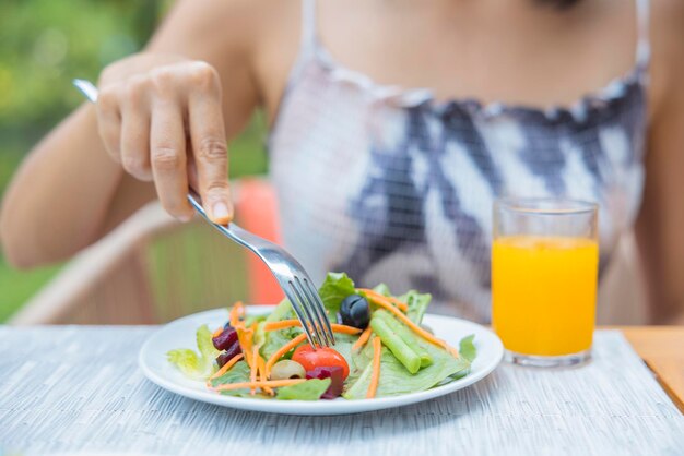 Primo piano di donna alzò un piatto di insalata di verdure Ragazza godetevi l'insalata per il pranzo concetto di dieta di benessere Concetto di salute