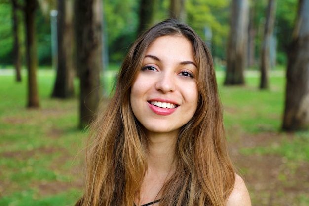 Primo piano di donna sorridente naturale all'aperto nel parco