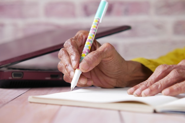 Primo piano di donne anziane che scrivono a mano sul blocco note