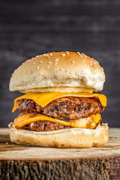 Primo piano di doppio hamburger di formaggio di manzo girato su tavola di legno