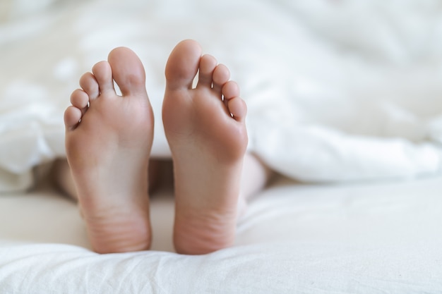 Primo piano di due piedi in un letto