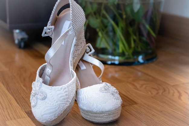 Primo piano di eleganti scarpe da sposa bianche ricamate