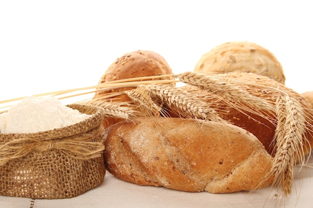 Primo piano di farina in un sacchetto e diversi tipi di pane Isolare