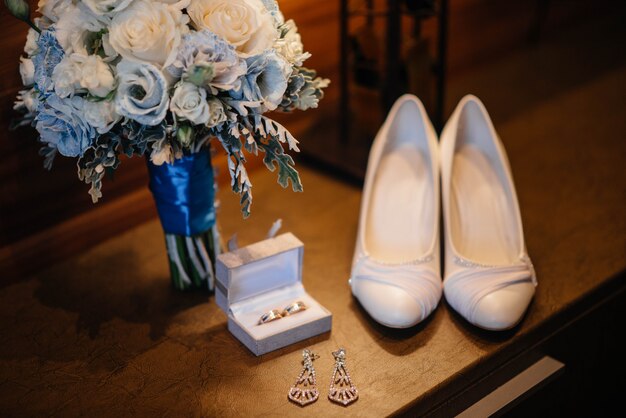 Primo piano di fedi nuziali e altri accessori durante la riunione della sposa. Nozze.