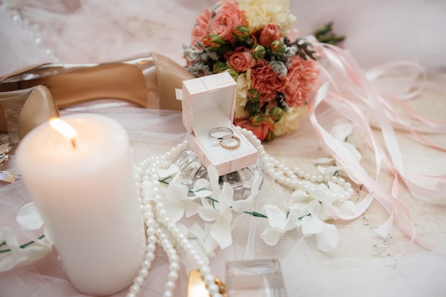 Primo piano di fedi nuziali e altri accessori durante la riunione della sposa. Nozze.