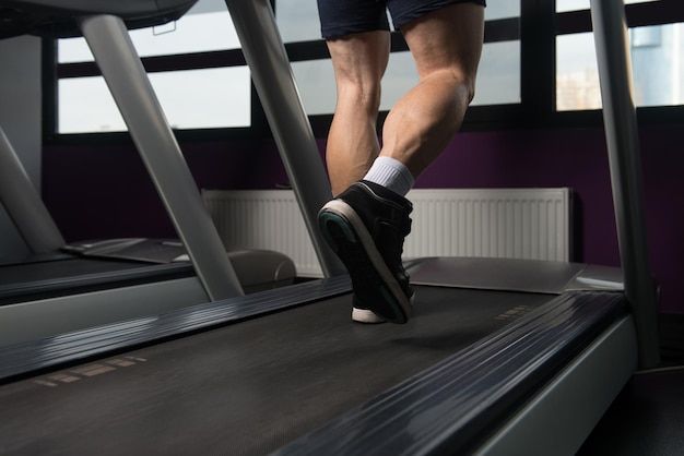 Primo piano di gambe maschili in esecuzione sul tapis roulant movimento sfocato