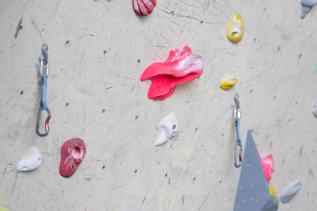 Primo piano di ganci colorati o impugnature con carabine per la parete da arrampicata