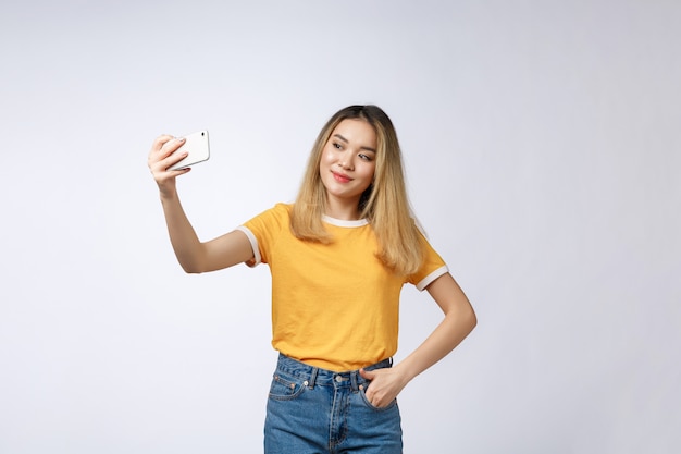 Primo piano di giovane bella donna asiatica che prende selfie