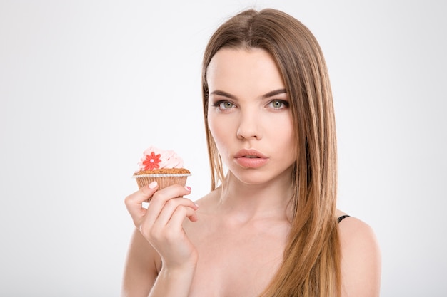 Primo piano di giovane bella donna sensuale naturale con cupcake gustoso