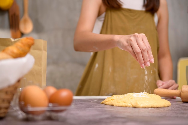 Primo piano di giovane bella donna sta cuocendo nella sua cucina panetteria e caffetteria