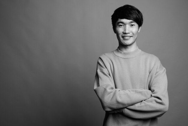 Primo piano di giovane uomo asiatico che indossa un maglione