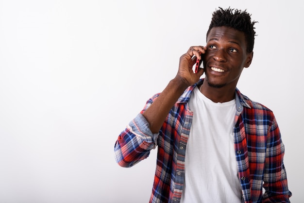 Primo piano di giovane uomo felice sorridente mentre parla al telefono