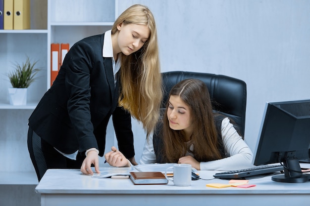 Primo piano di giovani ragazze che lavorano insieme su un progetto comune in ufficio