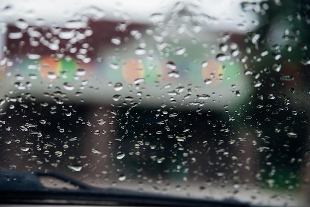 Primo piano di gocce di pioggia su vetro trasparenteSfondo sfocato di silhouette landscapeThe texture di vetro bagnato Sfondo astratto