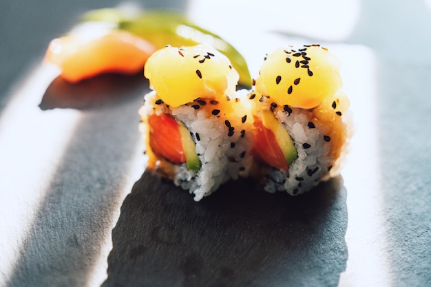 Primo piano di gustosi sushi uramaki giapponesi con salmone