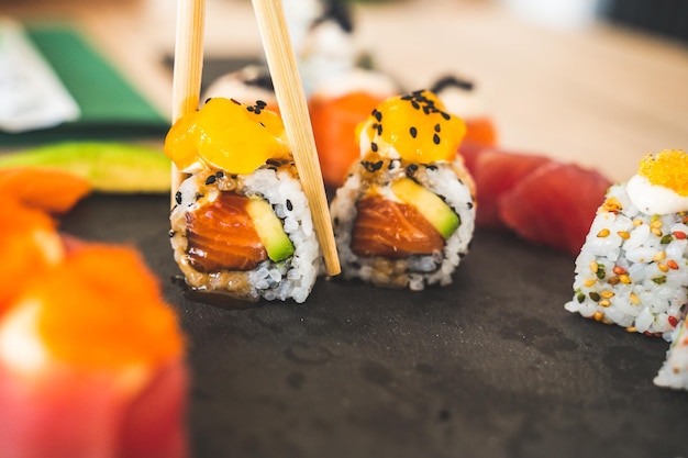 Primo piano di gustosi sushi uramaki giapponesi con salmone