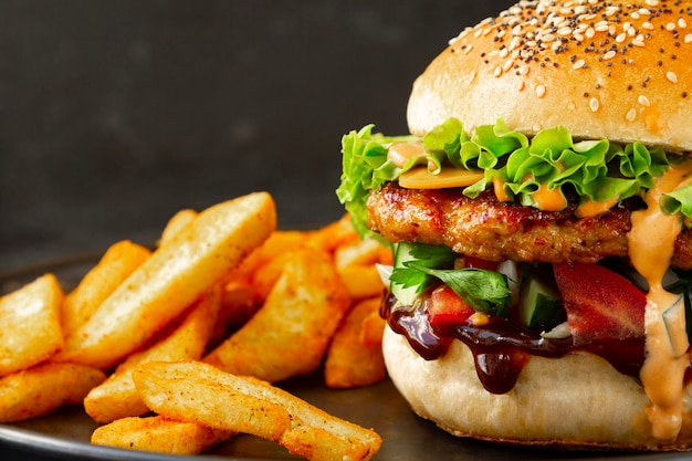 Primo piano di hamburger di pollo fresco e gustoso con patatine fritte