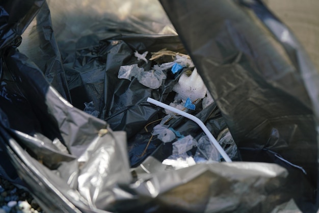 Primo piano di immondizia di plastica in un sacchetto della spazzatura cannuccia