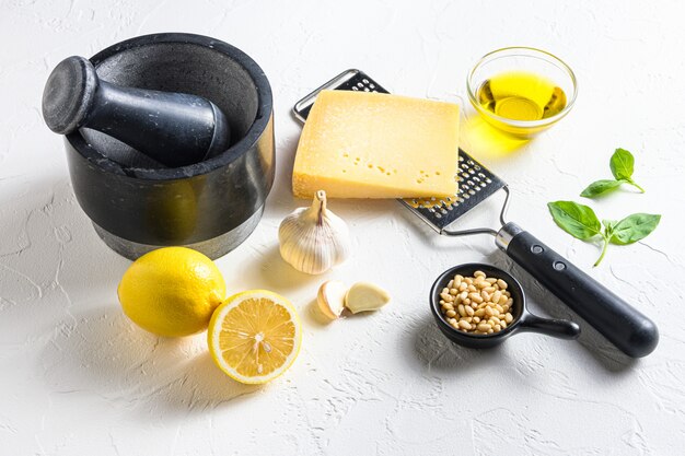 Primo piano di ingredienti per il pesto: basilico, parmigiano e limone