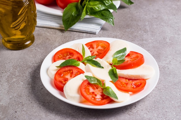 Primo piano di insalata caprese con pomodori maturi basilico mozzarella di bufala italiana e me