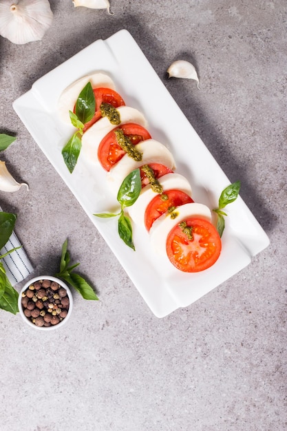 Primo piano di insalata caprese con pomodori maturi basilico mozzarella di bufala italiana e me