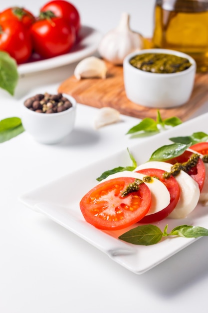 Primo piano di insalata caprese con pomodori maturi basilico mozzarella di bufala italiana e me