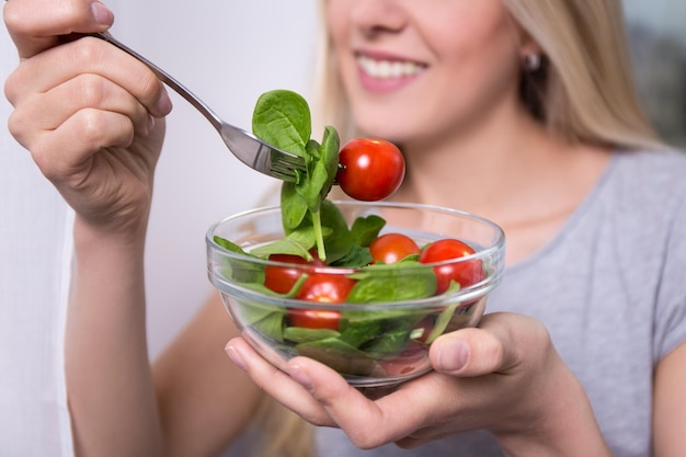 Primo piano di insalata con pomodori e spinaci in mani femminili