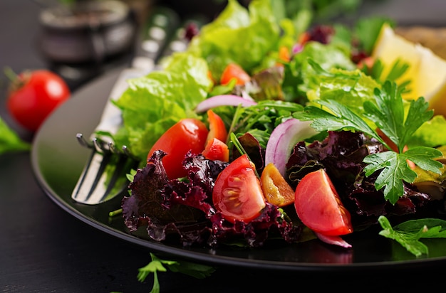 Primo piano di insalata di verdure su fondo scuro.