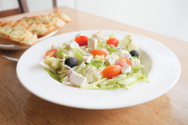 Primo piano di insalata greca in una ciotola sul tavolo.