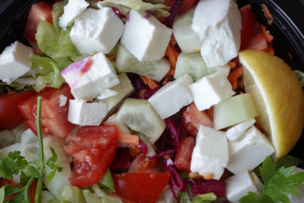 Primo piano di insalata greca in una ciotola sul tavolo.