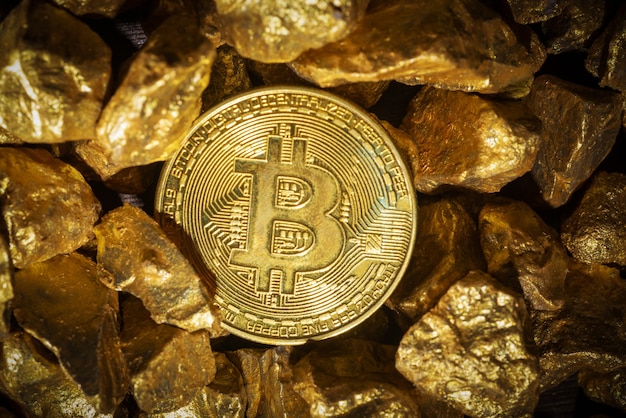 Primo piano di lingotti d'oro e bitcoin, concetto di criptovaluta finanziaria