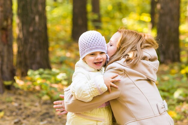 Primo piano di madre e figlia nel parco autunnale.