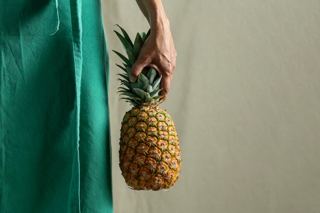 Primo piano di mani femminili che tengono una foto d'archivio di ananas